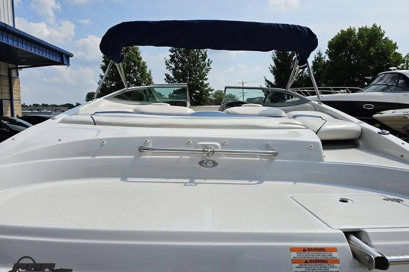 Slide: The Image of 2007 Crownline 23 SS boat with blue canopy, docked under a clear sky. - 30
