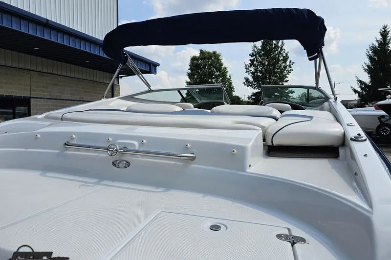 Slide: The Image of 2007 Crownline 23 SS boat with white seating and blue canopy, docked outdoors. - 33