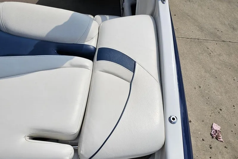 Slide: The Image of Crownline 23 SS 2007 boat seat with white and blue upholstery on concrete surface. - 38