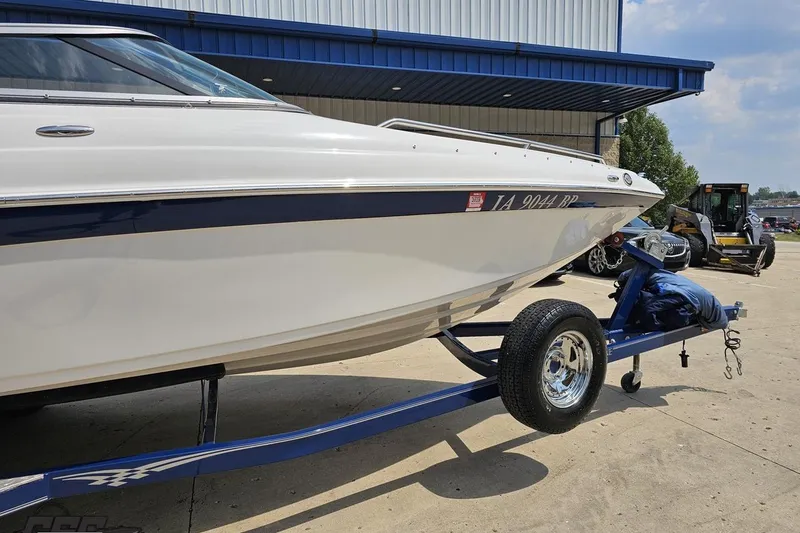Slide: The Image of 2007 Crownline 23 SS boat on trailer outside a blue-roofed building. - 4