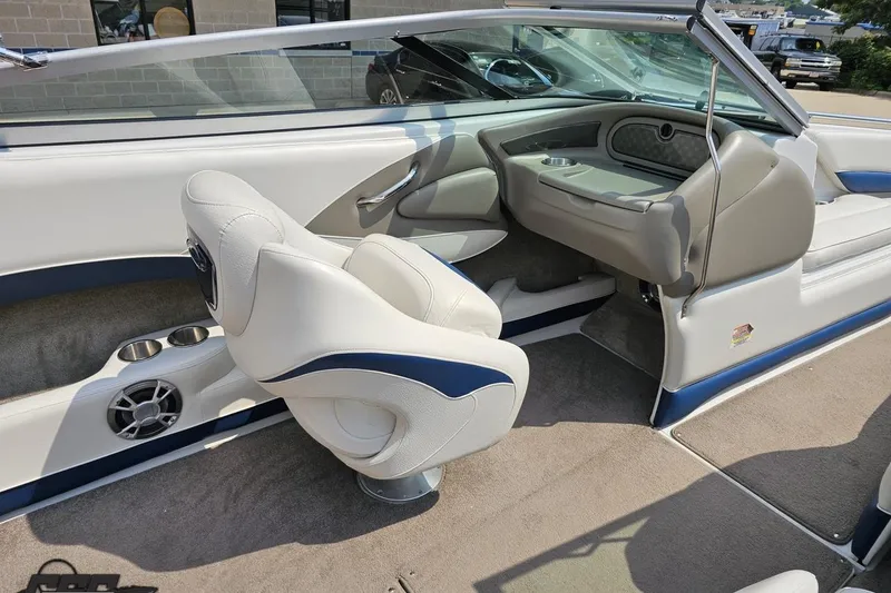 Slide: The Image of 2007 Crownline 23 SS boat interior with white and blue seating, cup holders, and steering area. - 45
