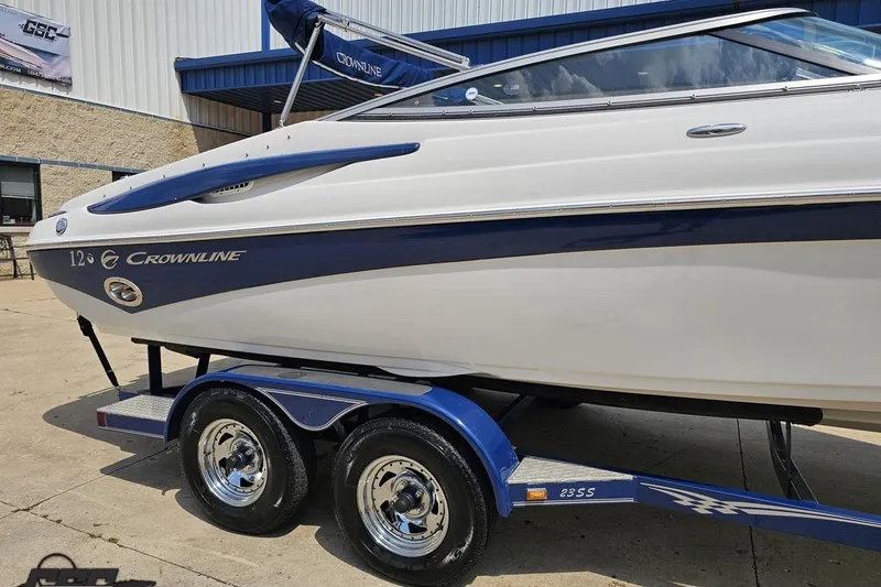 Slide: The Image of 2007 Crownline 23 SS boat on trailer, white and blue design, parked outdoors. - 5