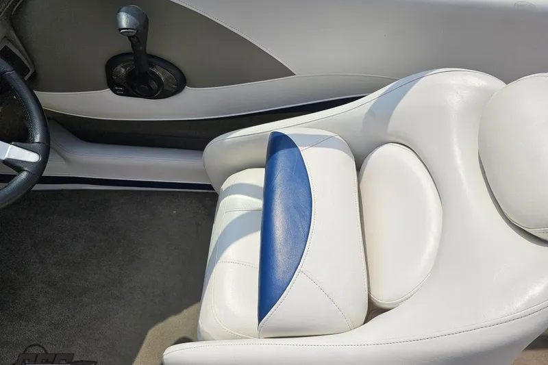 Slide: The Image of 2007 Crownline 23 SS boat interior with white and blue seating, steering wheel, and controls. - 55