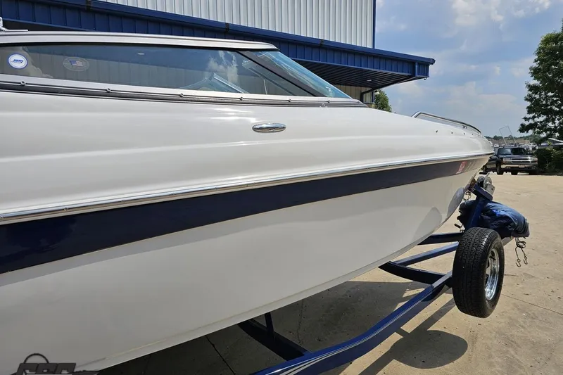 Slide: The Image of 2007 Crownline 23 SS boat on trailer, white and blue exterior, parked outdoors. - 7