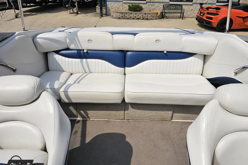 Slide: The Image of 2007 Crownline 23 SS boat interior with white and blue seating, parked outdoors. - 78