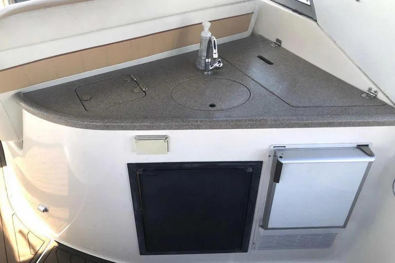 Slide: The Image of 2006 Rinker 342 Express Cruiser kitchenette with sink and storage compartments. - 11
