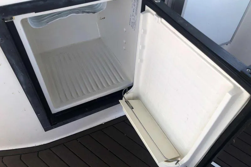 Slide: The Image of Open refrigerator on 2006 Rinker 342 Express Cruiser boat, showing empty interior. - 13
