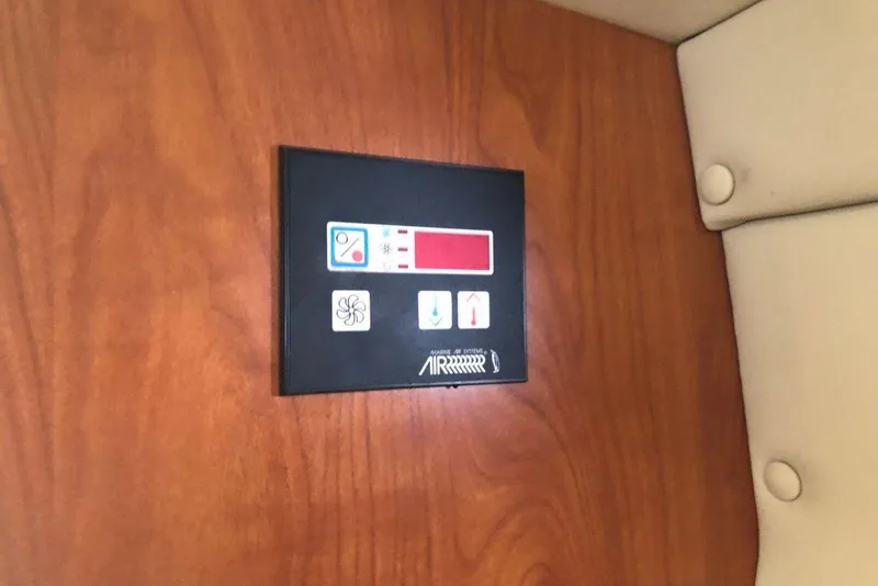 Slide: The Image of Control panel on 2006 Rinker 342 Express Cruiser, mounted on wooden surface. - 27