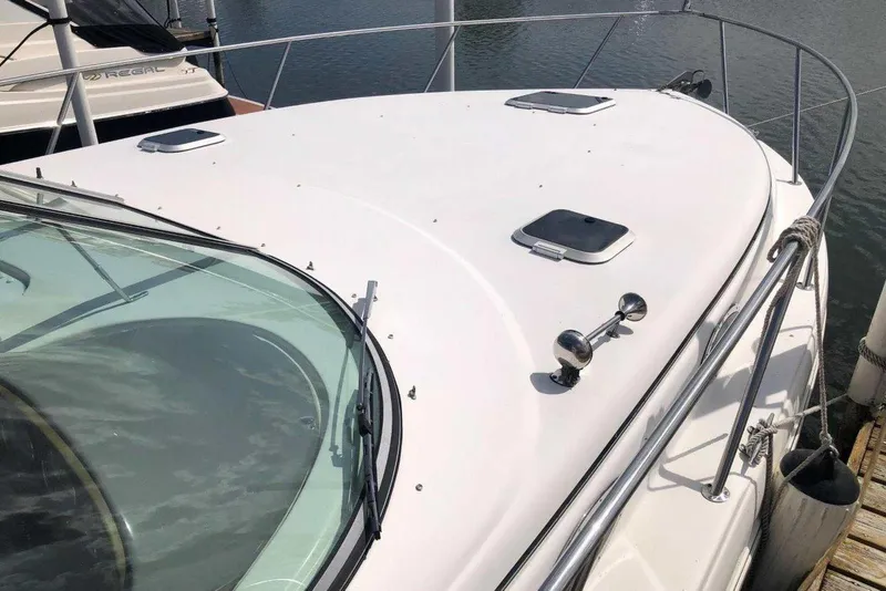 Slide: The Image of 2006 Rinker 342 Express Cruiser boat deck with hatches and railing, docked at marina. - 3