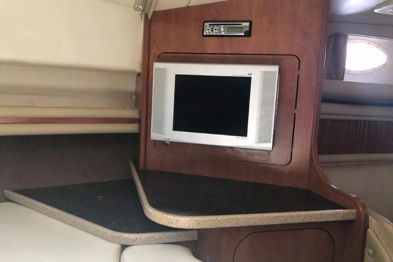 Slide: The Image of 2006 Rinker 342 Express Cruiser interior with TV and wooden cabinetry. - 32