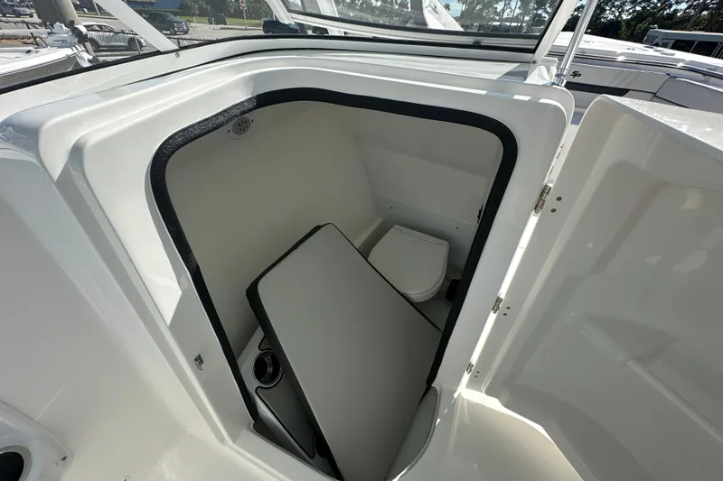 Slide: The Image of 2026 Sea Pro 240 Dual Console boat interior with compact marine toilet. - 11