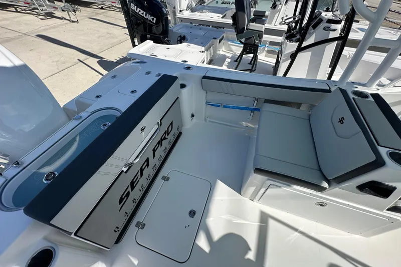 Slide: The Image of 2026 Sea Pro 240 Dual Console boat interior with seating and Suzuki engine. - 14