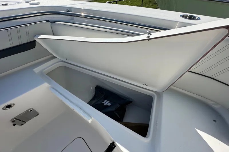 Slide: The Image of 2026 Sea Pro 240 Dual Console boat storage compartment open, showcasing interior space. - 8