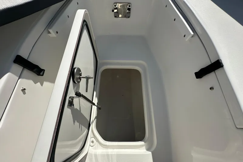 Slide: The Image of 2026 Sea Pro 240 Dual Console storage compartment with open hatch. - 9