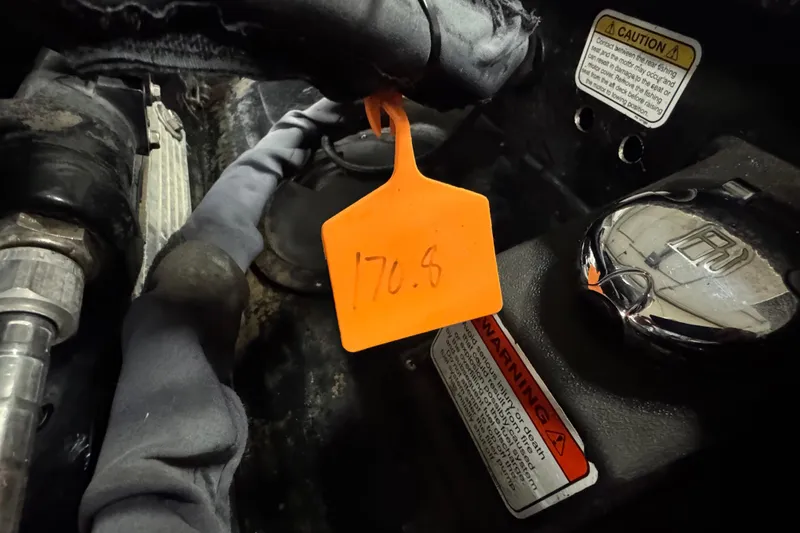 Slide: The Image of 2017 Tracker Pro Guide V-175 Combo engine compartment with caution labels and orange tag. - 5