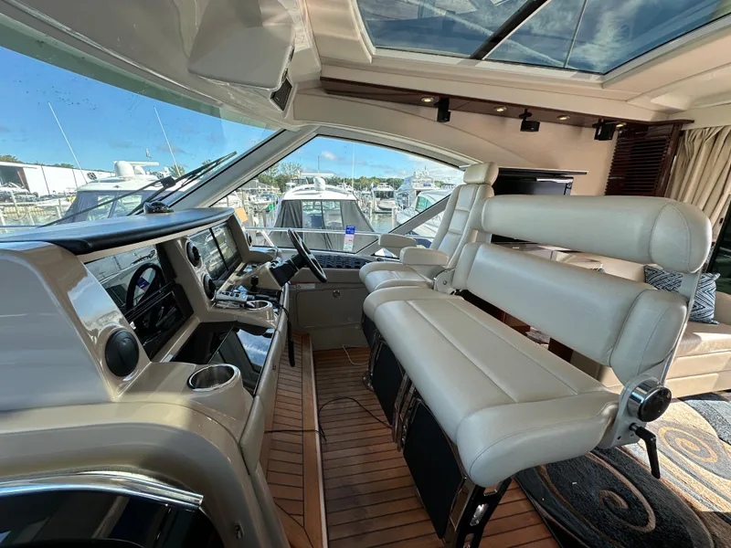 Slide: The Image of Interior of 2009 Sea Ray 60 Sundancer yacht with luxurious seating and modern dashboard. - 10