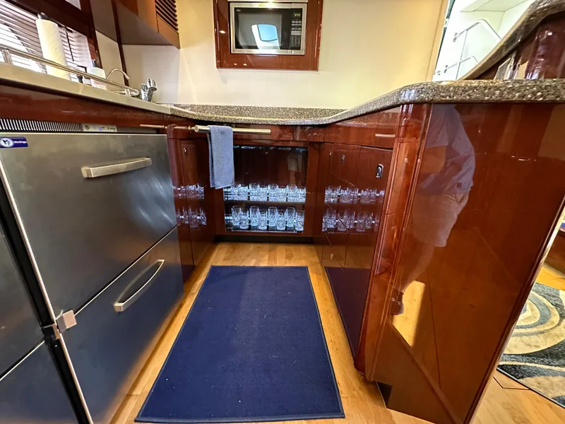 Slide: The Image of Luxurious kitchen area in 2009 Sea Ray 60 Sundancer yacht with modern appliances and wood cabinetry. - 19