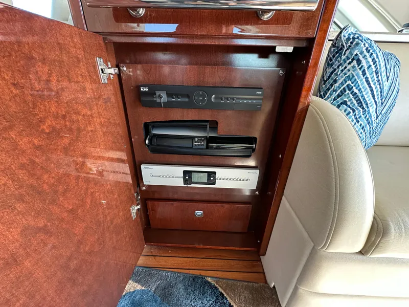 Slide: The Image of 2009 Sea Ray 60 Sundancer interior cabinet with electronic equipment and plush seating. - 9