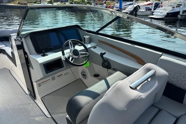 Slide: The Image of 2026 Regal LS9 boat interior with modern dashboard and steering, docked at marina. - 2