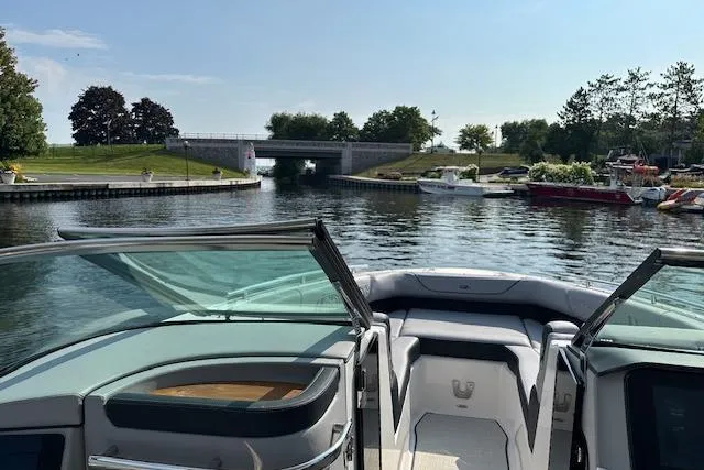 Slide: The Image of 2026 Regal LS9 boat cruising on a scenic river with a bridge ahead. - 6