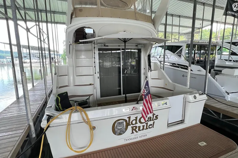 Slide: The Image of 2005 Carver 33 Super Sport yacht docked on a sunny day with trees in the background. - 1