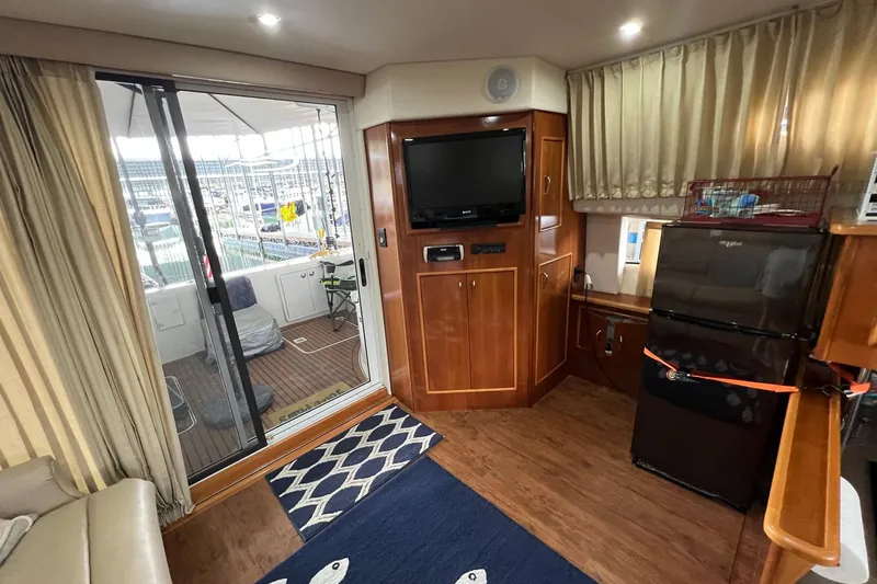 Slide: The Image of 2005 Carver 33 Super Sport yacht deck with table, chairs, and sliding glass doors. - 8