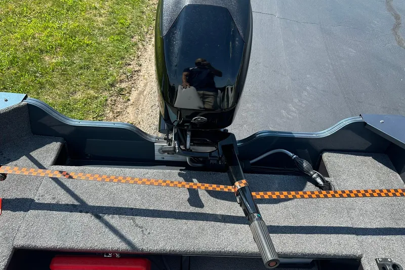Slide: The Image of 2013 Crestliner 16 Kodiak boat with outboard motor, parked on pavement near grass. - 15