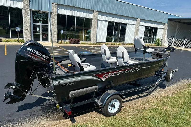 Slide: The Image of 2013 Crestliner 16 Kodiak boat with Mercury engine parked outside dealership. - 2