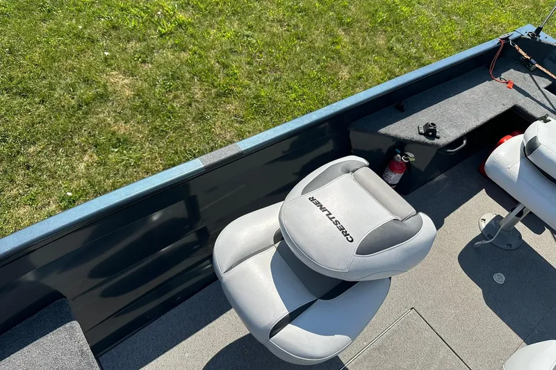 Slide: The Image of 2013 Crestliner 16 Kodiak boat interior with seating and fire extinguisher, on grassy background. - 23