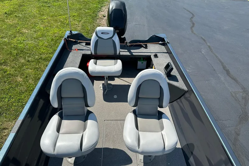 Slide: The Image of 2013 Crestliner 16 Kodiak boat interior with three gray seats and a motor. - 6