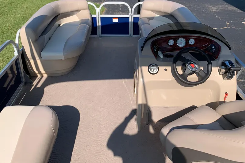 Slide: The Image of 2014 SUNTRACKER PARTY BARGE 18 interior with beige seating and steering console. - 7