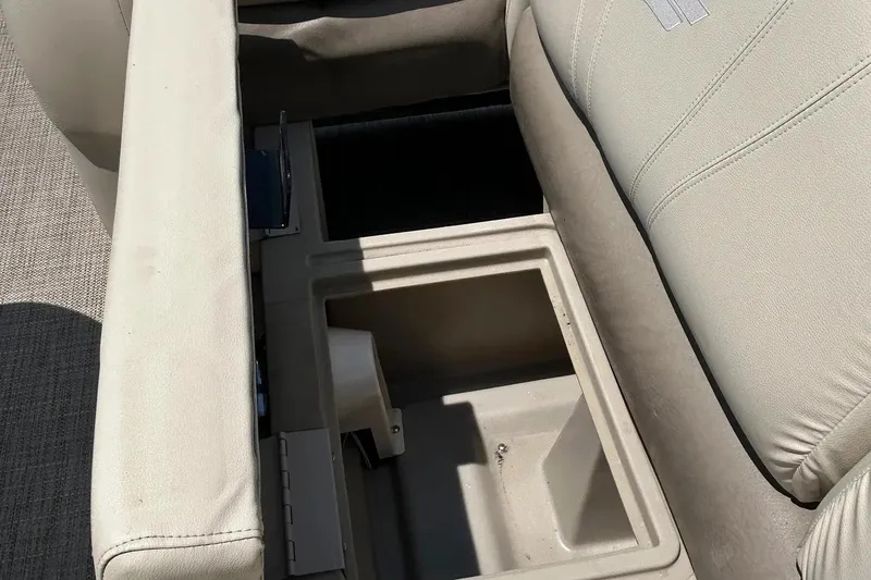 Slide: The Image of 2017 Starcraft CX 23 RE boat seat storage compartment, open with beige upholstery. - 13