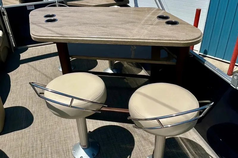 Slide: The Image of 2017 Starcraft CX 23 RE boat interior with table and swivel stools. - 14