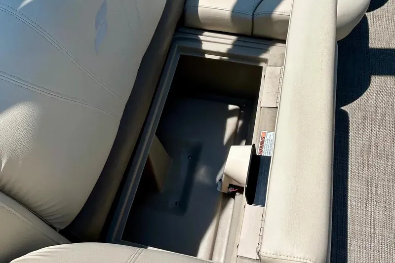 Slide: The Image of 2017 Starcraft CX 23 RE boat seat storage compartment, open with beige upholstery. - 18