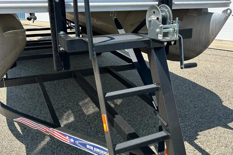 Slide: The Image of 2017 Starcraft CX 23 RE pontoon boat trailer with winch and ladder on asphalt. - 3