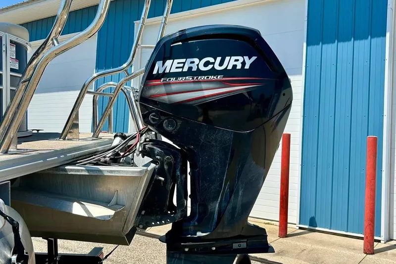 Slide: The Image of 2017 Starcraft CX 23 RE with Mercury FourStroke outboard motor, parked near blue building. - 33