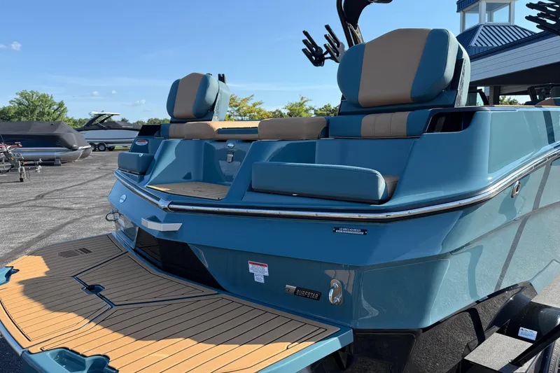 Slide: The Image of 2025 MasterCraft XT24 boat with blue exterior and tan seating, docked outdoors. - 11