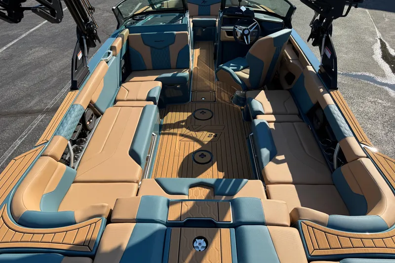 Slide: The Image of 2025 MasterCraft XT24 boat interior with tan and blue seating, spacious layout, and modern design. - 13