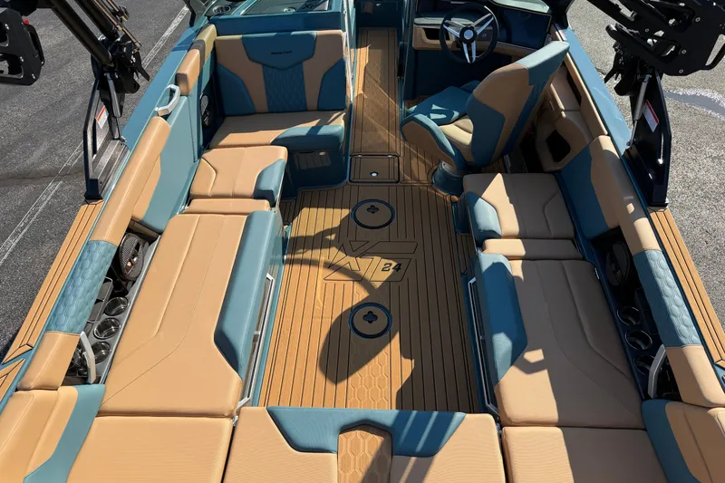 Slide: The Image of 2025 MasterCraft XT24 boat interior with tan and blue seating, sleek design, and modern steering. - 14