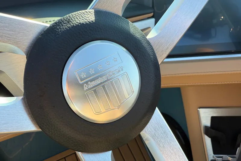 Slide: The Image of Steering wheel of 2025 MasterCraft XT24 boat, featuring sleek metallic design. - 25