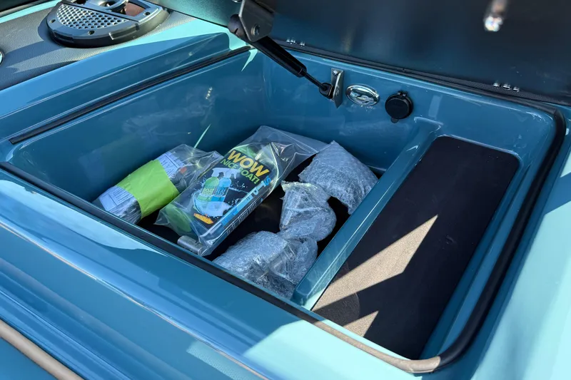 Slide: The Image of Open storage compartment in 2025 MasterCraft XT24 boat with cleaning supplies. - 30