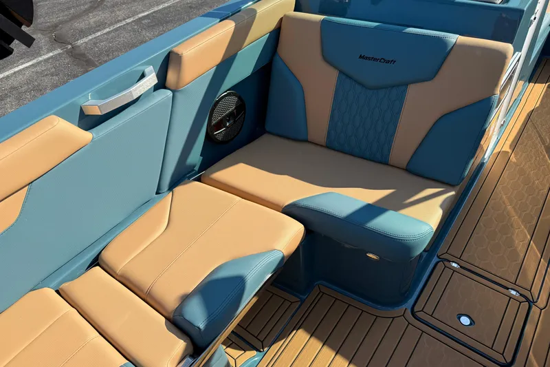 Slide: The Image of 2025 MasterCraft XT24 boat interior with tan and blue seating, featuring premium upholstery. - 34