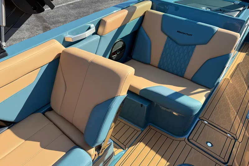 Slide: The Image of 2025 MasterCraft XT24 boat interior with blue and tan seating, showcasing luxury design. - 35