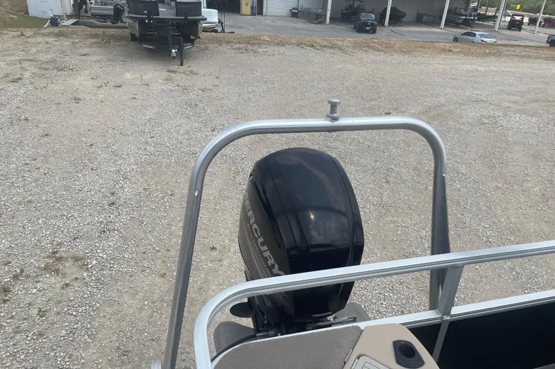 Slide: The Image of 2016 Sun Tracker Fishin' Barge 20 DLX with Mercury outboard motor in a gravel lot. - 10