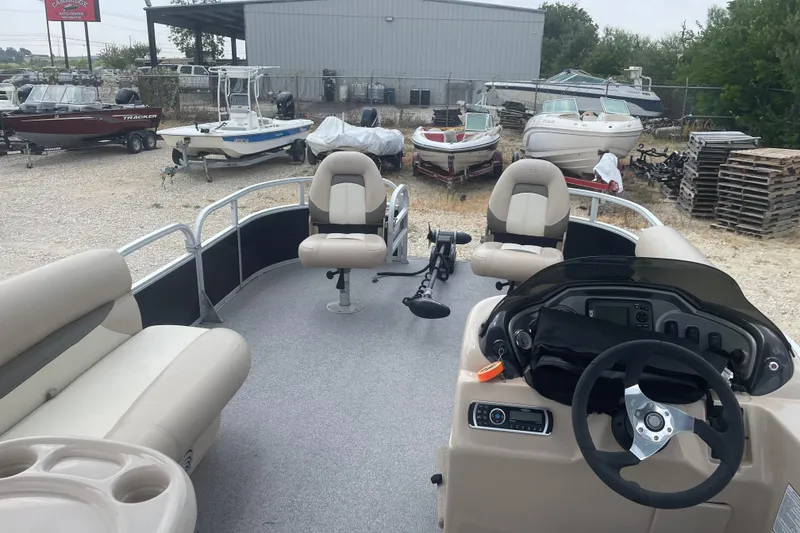 Slide: The Image of 2016 Sun Tracker Fishin' Barge 20 DLX pontoon boat interior with seating and steering console. - 11