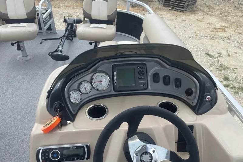 Slide: The Image of 2016 Sun Tracker Fishin' Barge 20 DLX dashboard with gauges and controls. - 12