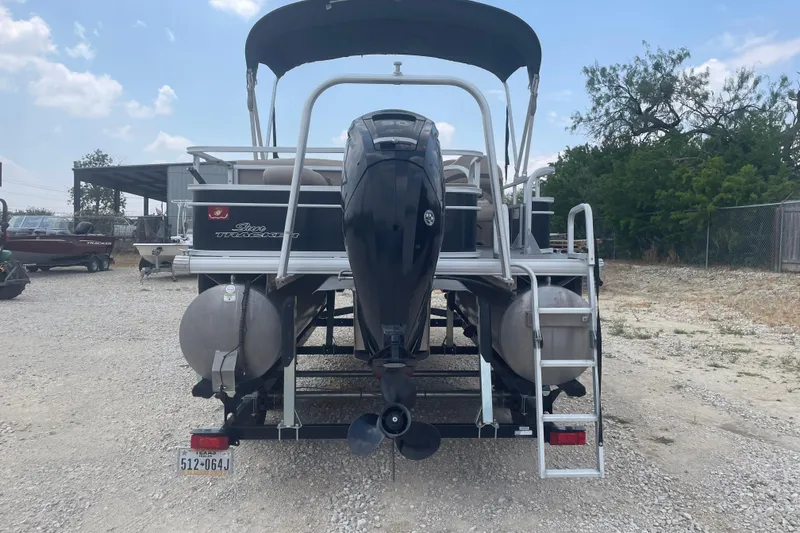 Slide: The Image of 2016 Sun Tracker Fishin' Barge 20 DLX pontoon boat, rear view with motor and ladder. - 2