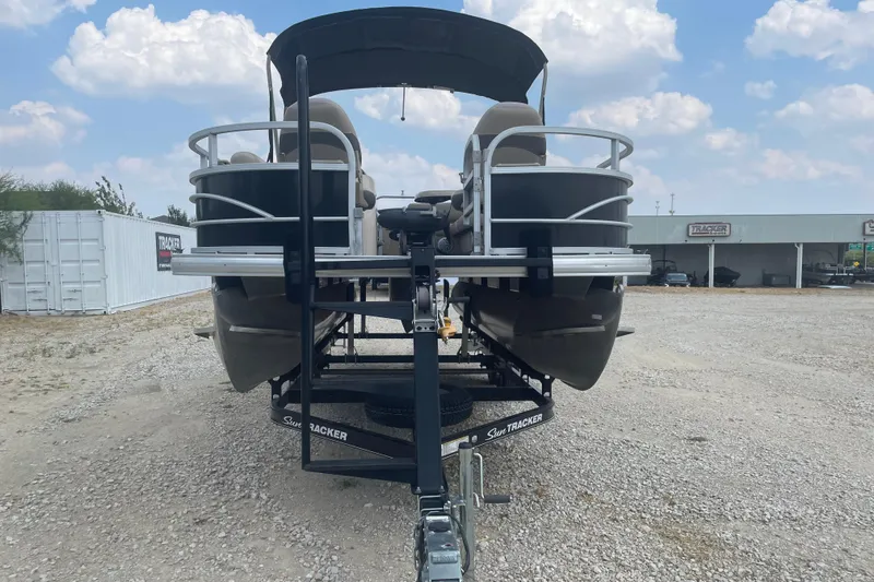 Slide: The Image of 2016 Sun Tracker Fishin' Barge 20 DLX pontoon boat on trailer, outdoor dealership setting. - 5