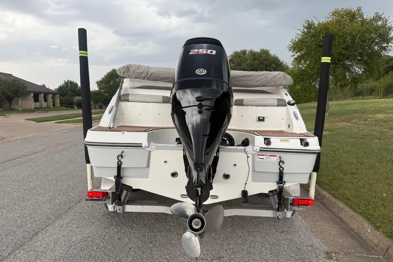 Slide: The Image of Suzuki four-stroke outboard motor on 2017 Hurricane SD 2486 boat, grassy background. - 23