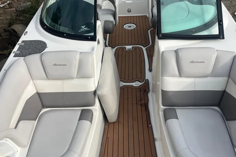 Slide: The Image of 2017 Hurricane SD 2486 boat interior with white and gray seating, brown deck flooring. - 66